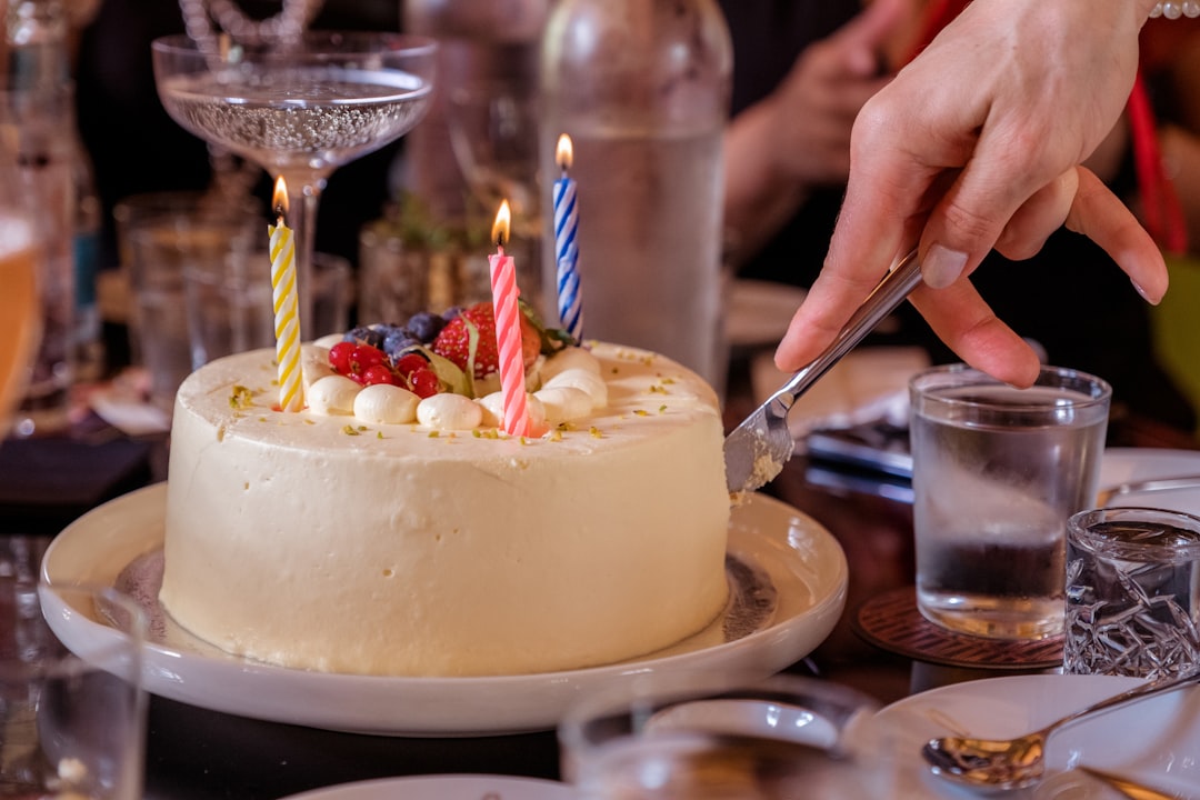 Close-up of a festive birthday cake with many lit candles, ready for someone to make a wish and blow them out.