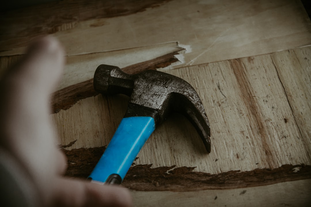 A person's hand gently knocking on a rustic wooden surface, symbolizing the ancient tradition and superstition of knocking on wood for good luck.