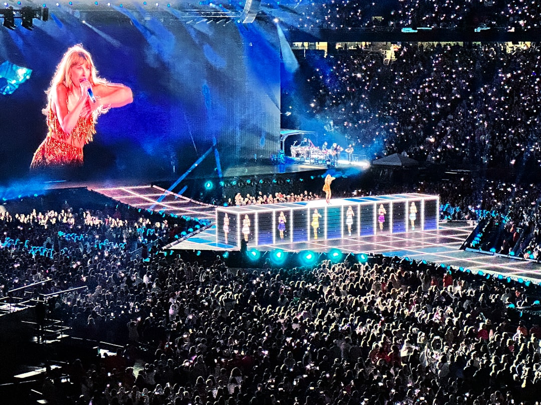 Thousands of fans at a Taylor Swift concert exchanging friendship bracelets, bathed in dazzling stage lights.