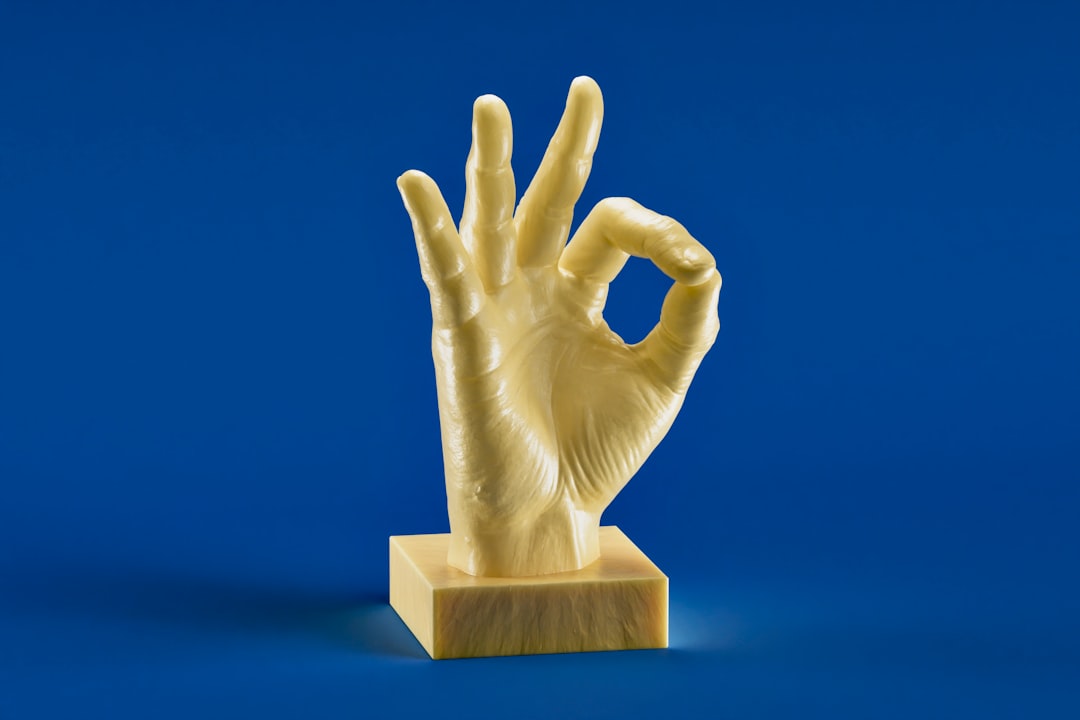 A hand giving a prominent thumbs up gesture, with subtle international flags or symbols in the background, representing its global use and potential for cultural misunderstanding.