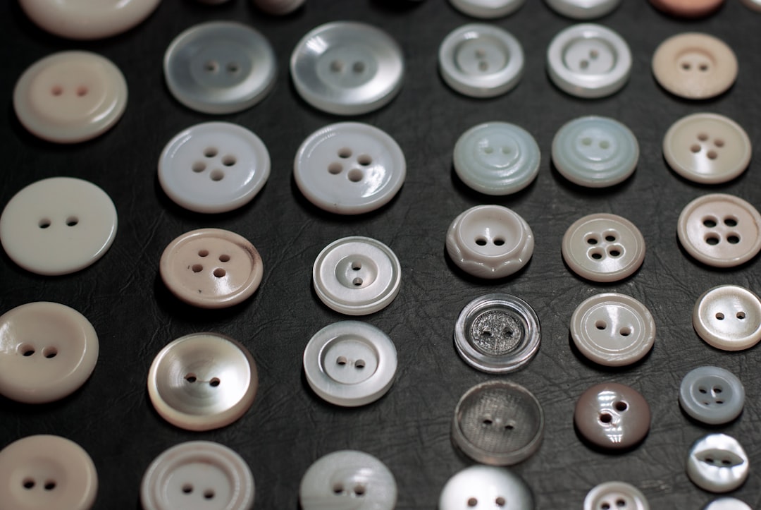 A side-by-side close-up showing the different button placements on a man's shirt (buttons on right) and a woman's shirt (buttons on left), highlighting a historical fashion detail.