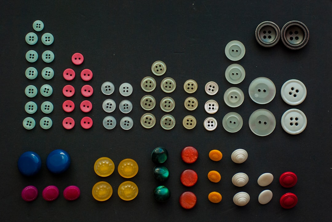 Close-up of two shirts side-by-side, one with buttons on the right (men's style) and the other with buttons on the left (women's style), illustrating the historical gender-based button placement.