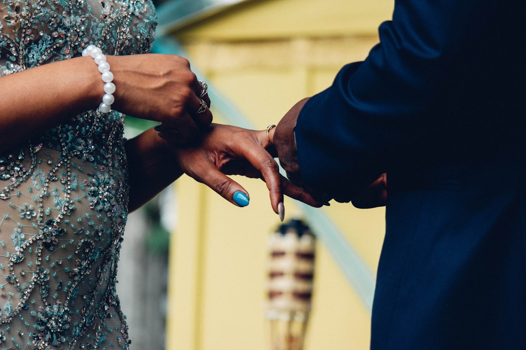 A gold wedding ring on the fourth finger of a hand, symbolizing love and the ancient tradition of the *vena amoris*.