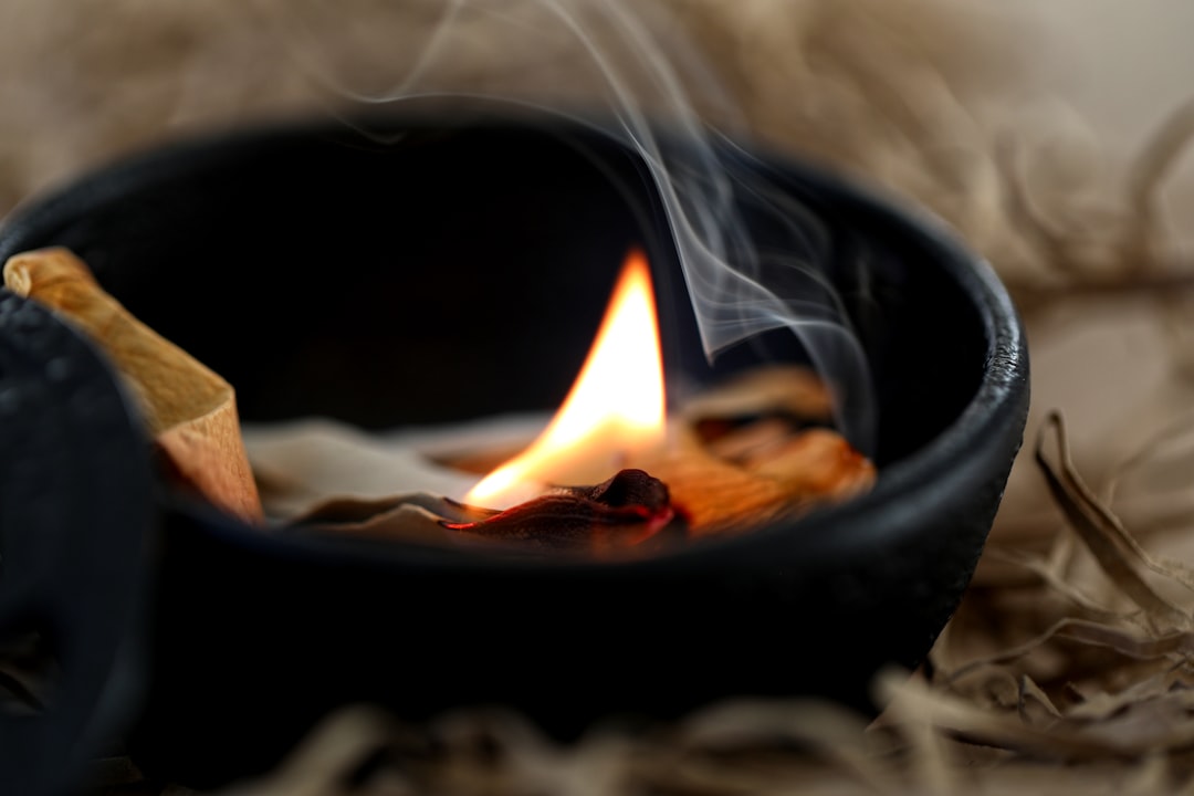 Açık bir pencere önünde tüten adaçayı demeti ve arka planda modern bir hava temizleyici cihaz. Adaçayı dumanının iç mekan hava kalitesine etkisini ve bilimsel gerçekleri temsil ediyor.
