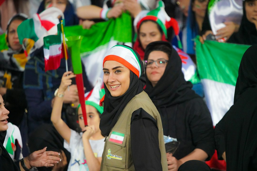 Iranian women watching a football match from a designated section in a stadium, symbolizing their fight for equal access.