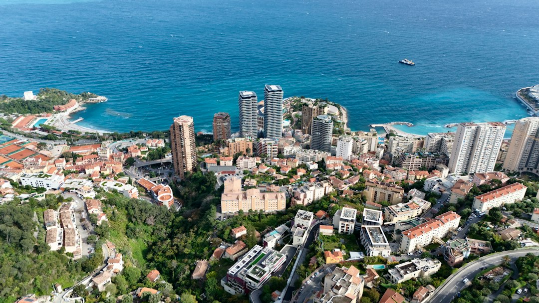 Aerial view of the Principality of Monaco, showing its coastline, densely built areas, and surrounding French Alps.